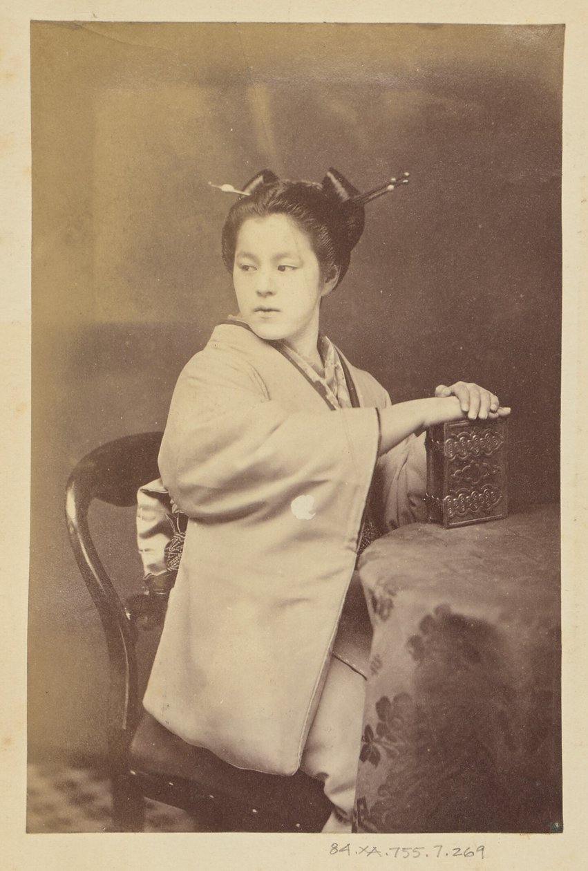 [Siedząca Japonka trzymająca przy stole album cartes-de-visite]. autorstwa Felice Beato