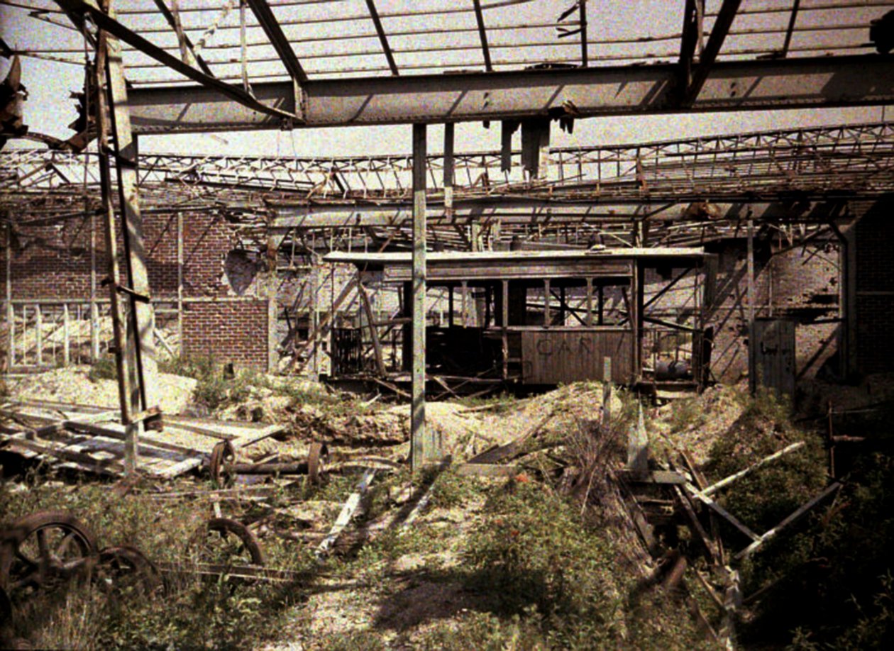 Spalona stocznia kolejowa i tramwajowa z kilkoma uszkodzonymi pojazdami i lokomotywą, Soissons, Aisne, Francja, 1917 (autochrom) autorstwa Fernand Cuville