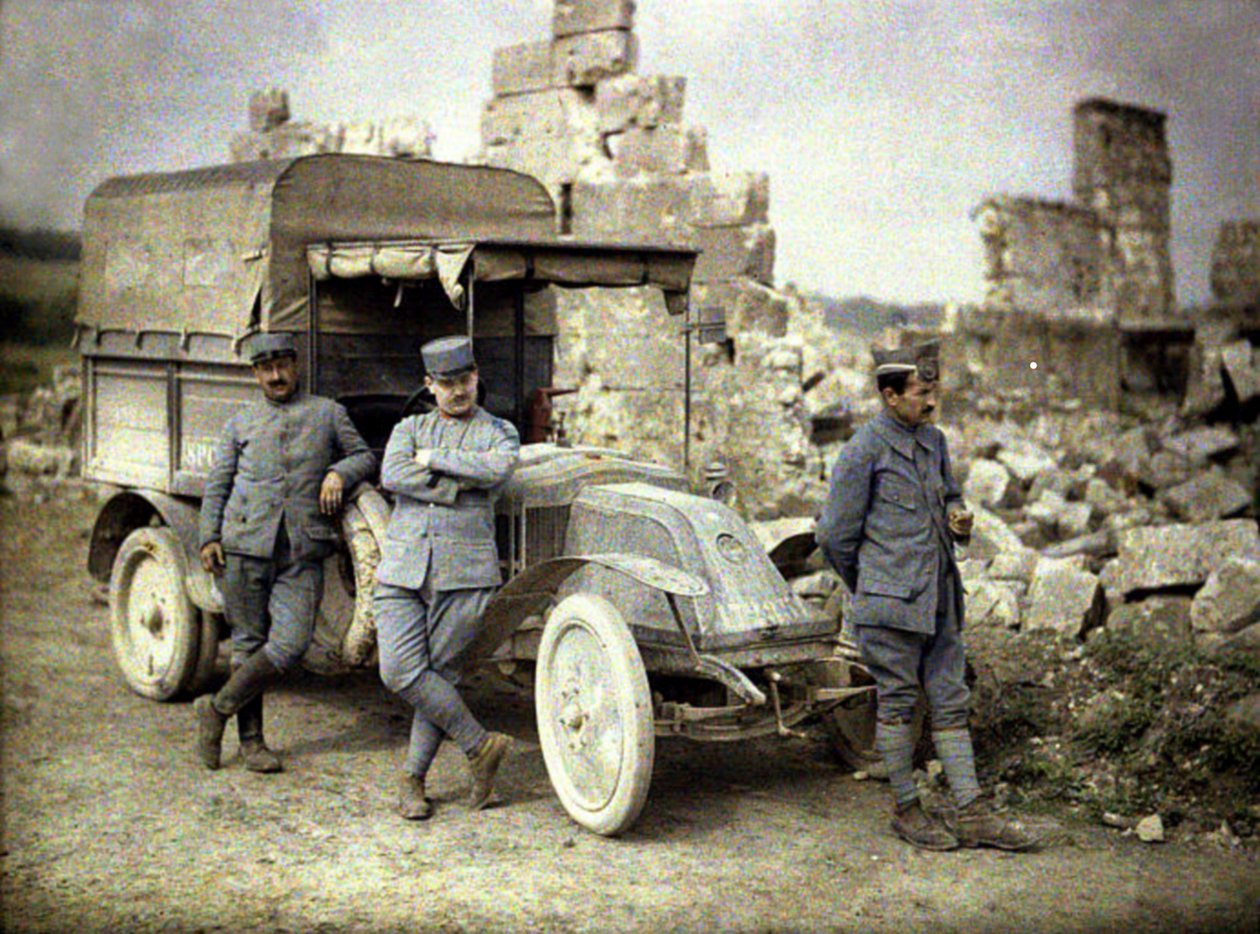 Trzech francuskich żołnierzy zaparkowanych przed mocno uszkodzonym budynkiem z małą ciężarówką, Aisne, Francja, 1917 (autochrome) autorstwa Fernand Cuville
