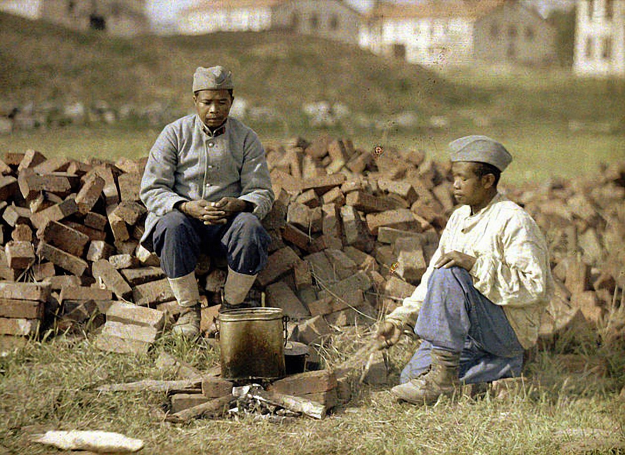 Dwóch afrykańskich żołnierzy podgrzewających posiłek, Soissons, Aisne, Francja, 1917 (autochrom) autorstwa Fernand Cuville