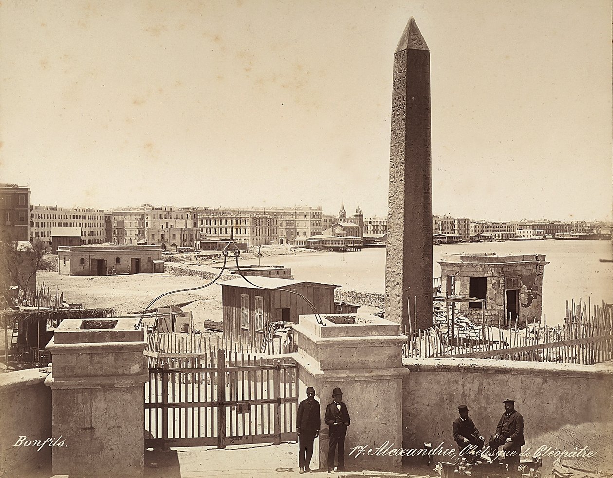 Aleksandria, Egipt: Obelisk Kleopatry, na którym czterech mężczyzn pozuje do zdjęcia autorstwa Félix Bonfils