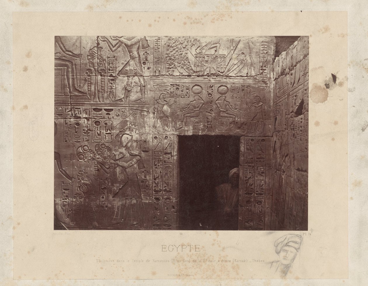 Mężczyzna w een deuropening w świątyni van Ramzesa III w Egipcie Rzeźby w Świątyni Ramzesa III, na tyłach II dziedzińca, po prawej (Karnak) - Teby (tytuł na obiekcie) Egipt (tytuł serii na obiekcie) autorstwa Félix Bonfils