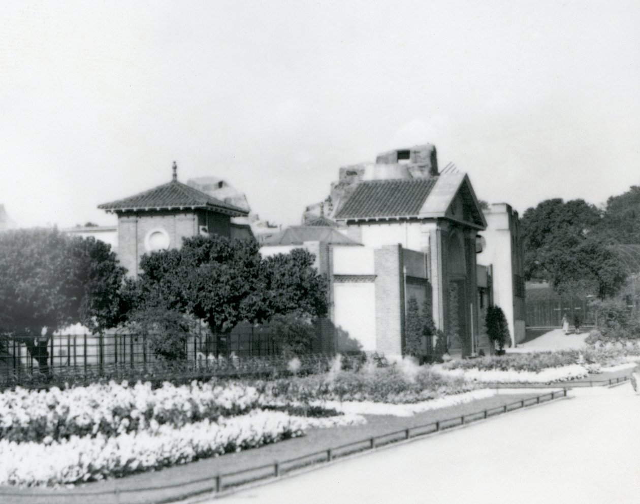 Reptile House w londyńskim zoo w 1928 roku z formalnymi klombami wzdłuż ścieżek prowadzących do wejścia, londyńskie zoo autorstwa Frederick William Bond