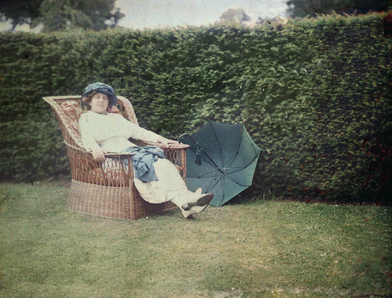 Kobieta siedząca na krześle ogrodowym (autochrome) autorstwa George Bernard Shaw