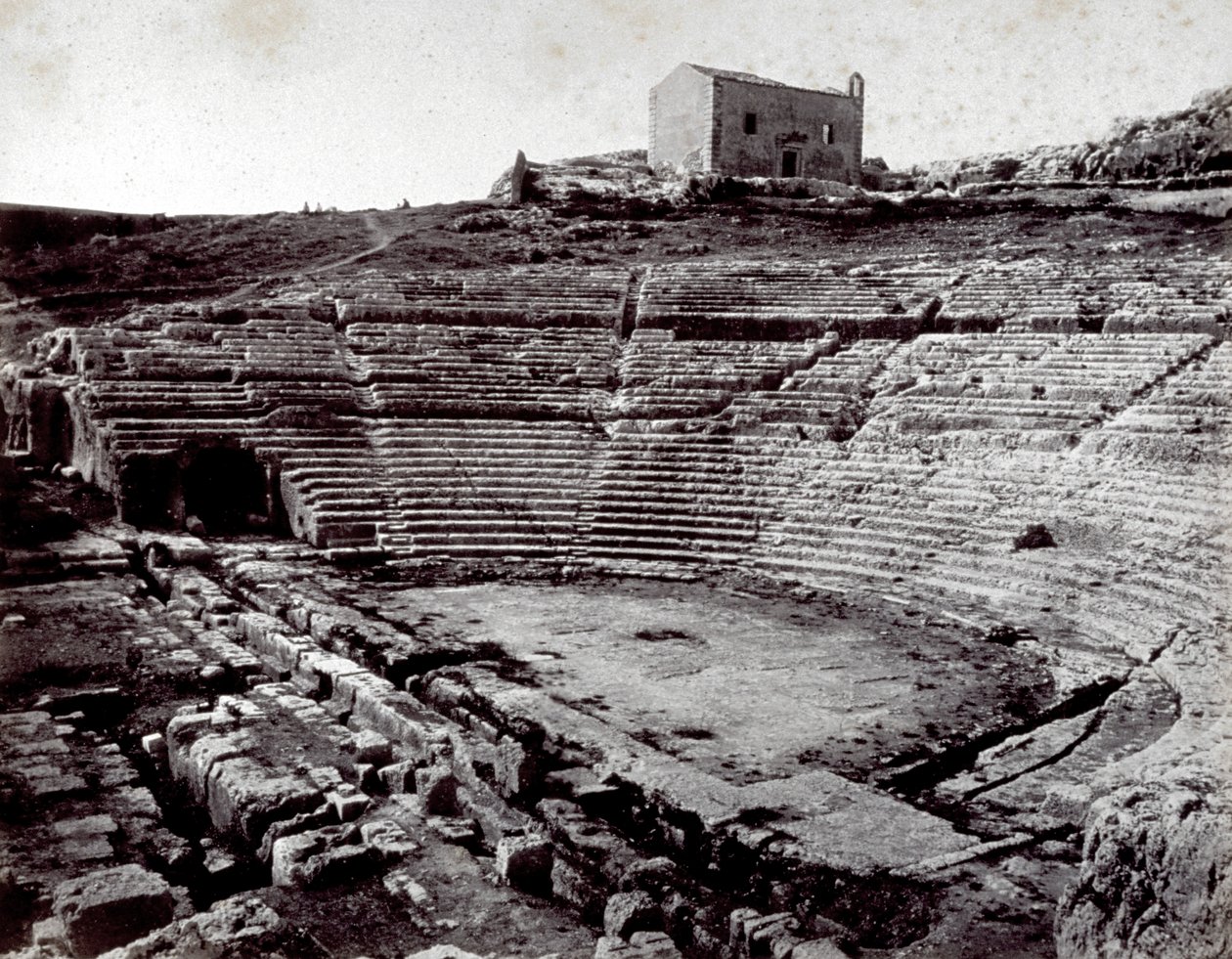 Pozostałości teatru greckiego w Syrakuzach w Monumental Park of the Neàpoll. Na pierwszym planie półkolista orkiestra i cavea autorstwa Giorgio Sommer