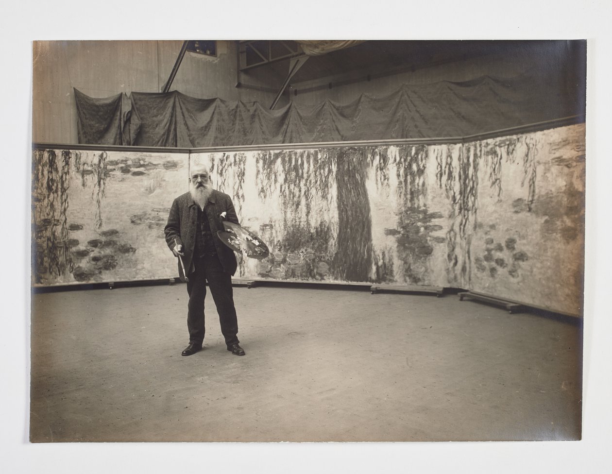 Claude Monet ze swoją paletą przed swoim dziełem „Les nymphéas” autorstwa Henri (attr. to) Manuel