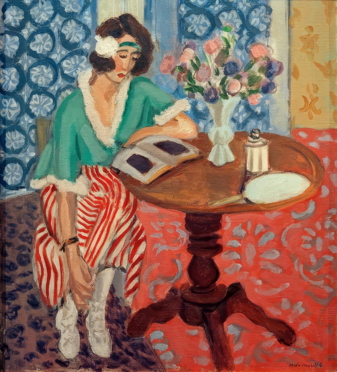 Kobieta czytająca przy stole (w zielonej sukience w czerwone paski) autorstwa Henri Matisse