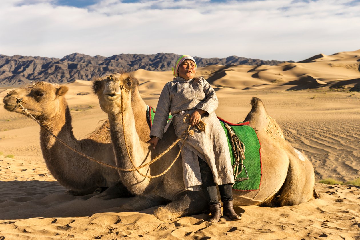 Kobieta odpoczywająca z wielbłądami na południowej pustyni Gobi, Mongolia, 2015 r. (zdjęcie ilustracyjne) autorstwa Ira Block
