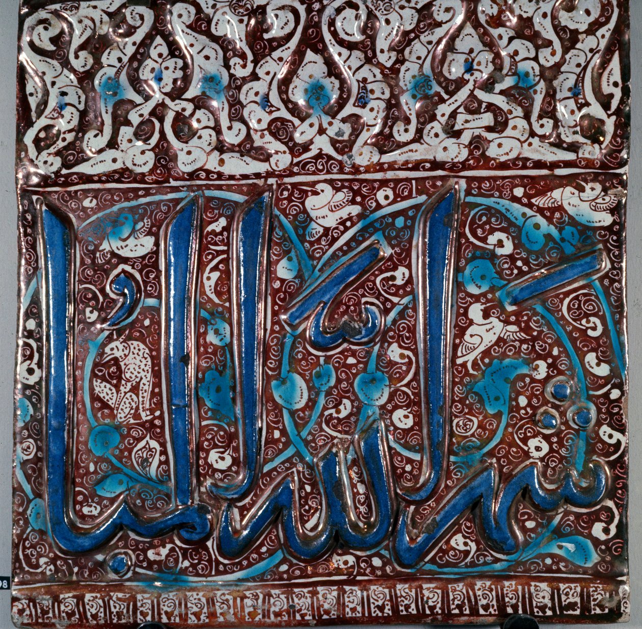 Sztuka Islamu: emalia ścienna ceramiczna typu „lajvardina” (lapis-lazuli) z napisem „Miesiąc Boga Beni”” z Kashan w Iranie. 13 wiek. Ciemny. 36x36 cm Muzeum Archeologiczne w Teheranie, Iran autorstwa Islamic School