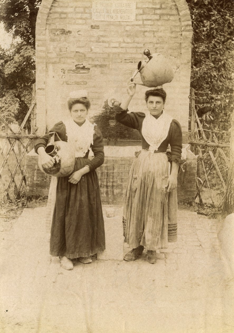 Dwie młode kobiety w tradycyjnych strojach niosące słoiki z terakoty w pobliżu studni, Marche, Włochy, ok. 1910 r. autorstwa Italian Photographer