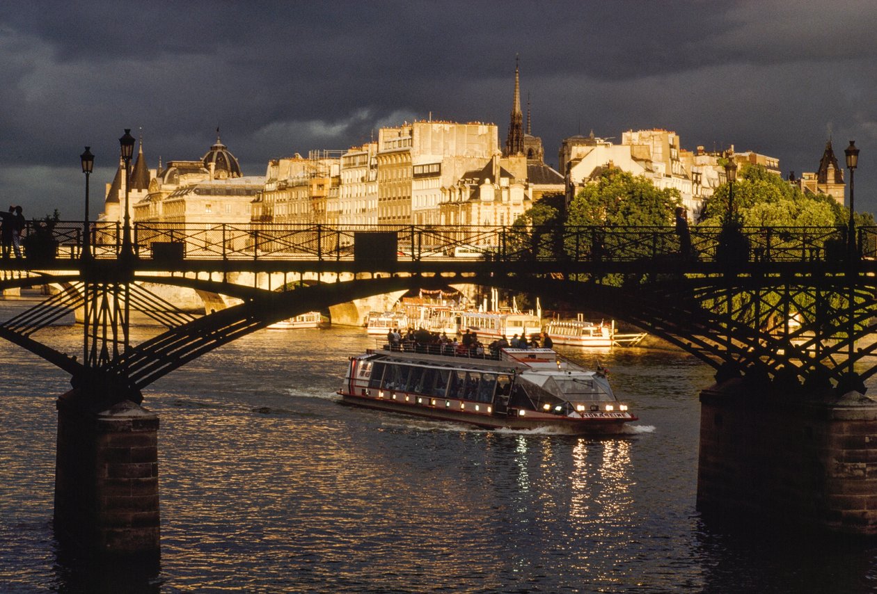 Ciemne chmury nad głową, gdy łódź przepływa pod Pont des Arts. Sekwana, Pa... autorstwa James L Stanfield