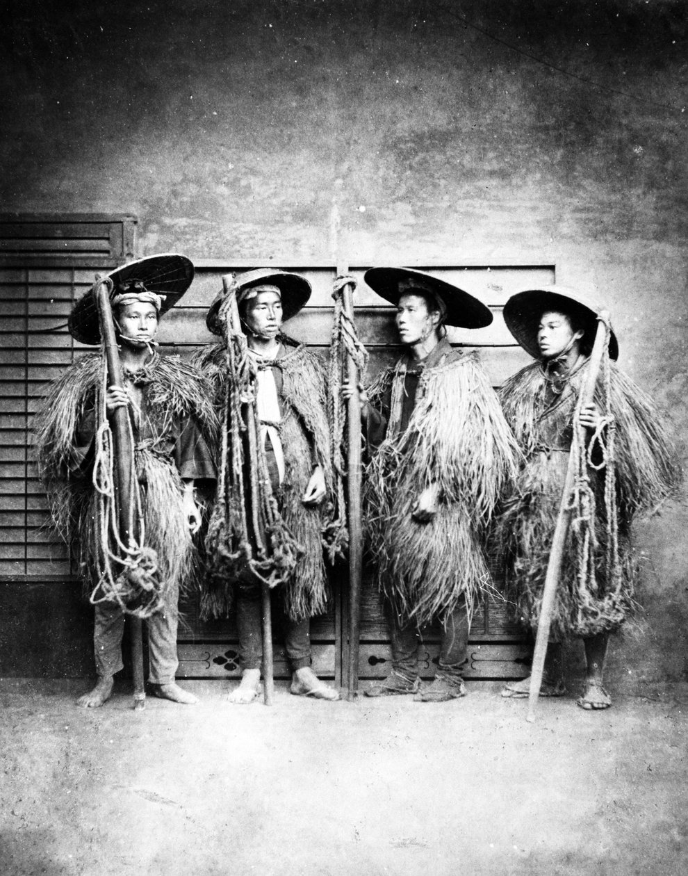 Japońscy mężczyźni w słomkowych płaszczach, ok. 1870 r. autorstwa Japanese Photographer