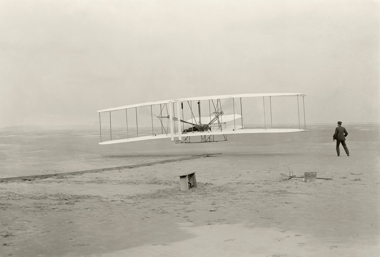 Wright Flyer I wykonuje swój pierwszy lot 120 stóp w 12 sekund, w Kitty Hawk w Północnej Karolinie autorstwa John T. Daniels