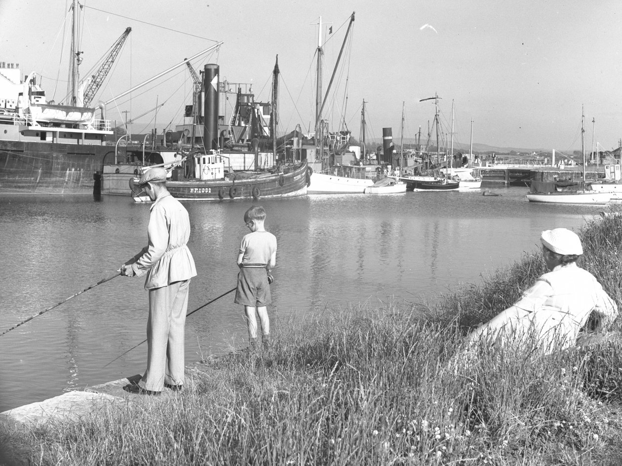 Mężczyzna i chłopiec łowiący ryby w Glasson Dock na tle morza; pejzaż morski; z tyłu przycumowane różne łodzie autorstwa Joseph Hardman