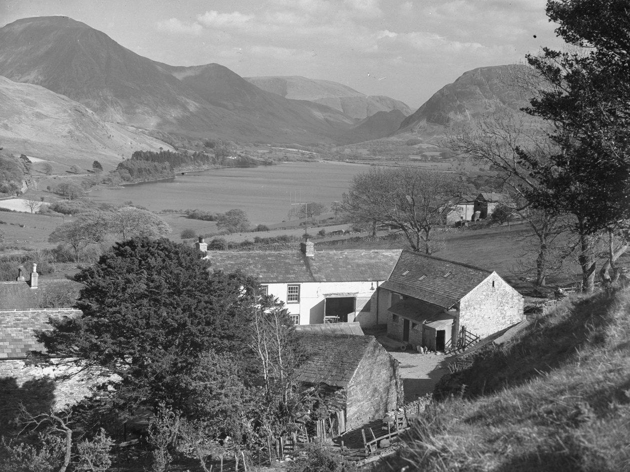 Widok na coś, co wydaje się być farmą na pierwszym planie oraz jezioro i wzgórza w tle. autorstwa Joseph Hardman
