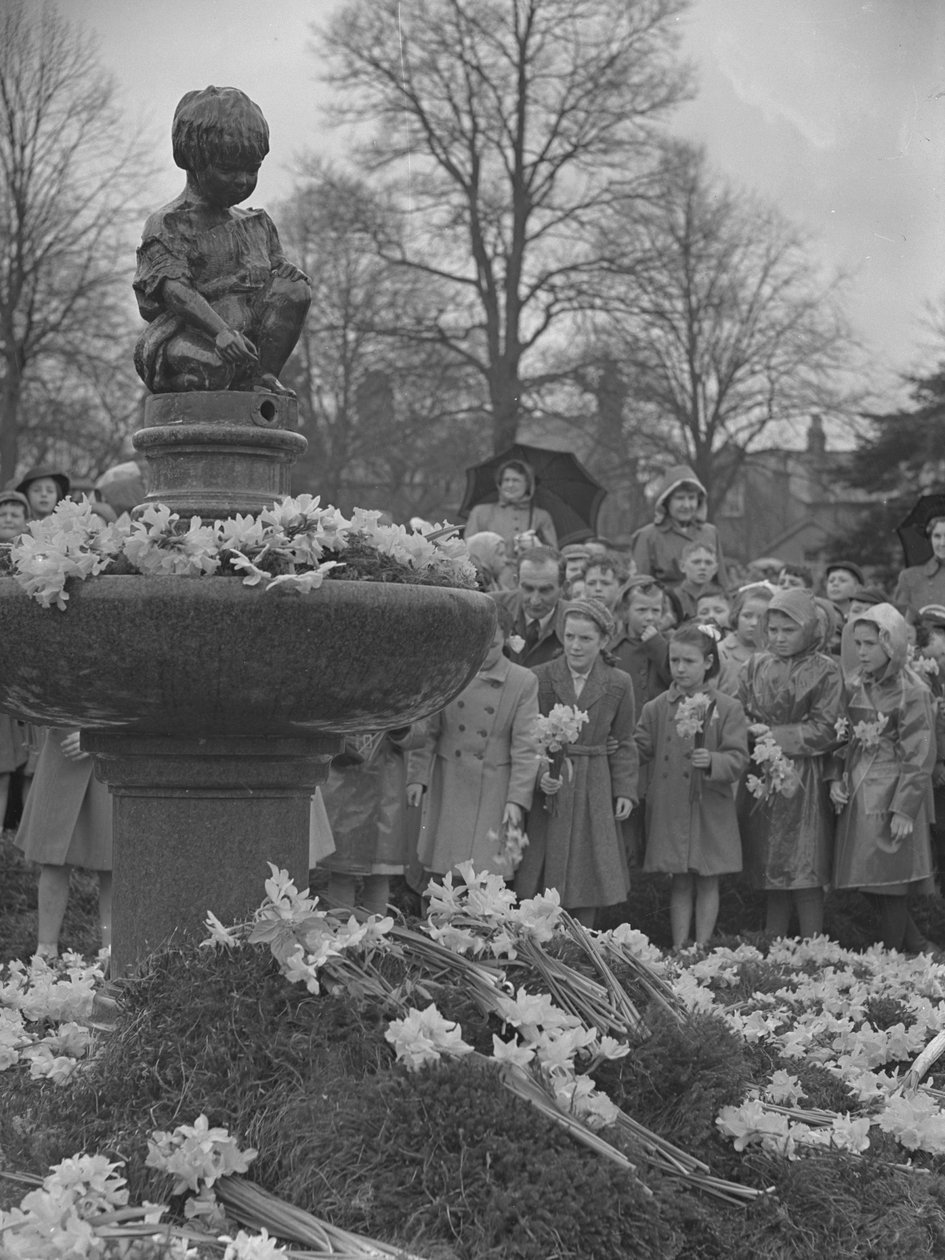Dzieci umieszczające wiązanki żonkili na fontannie z posągiem na szczycie autorstwa Joseph Hardman