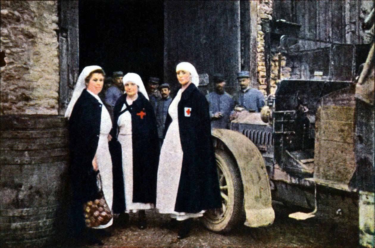 Trzy kobiety noszące Czerwony Krzyż i francuski personel pogotowia ratunkowego z pojazdem, Verdun, wrzesień 1916 (autochrome) autorstwa Jules Gervais Courtellemont