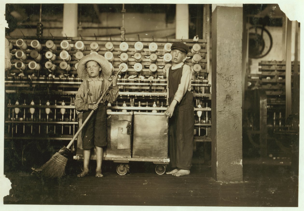 12-letni doffer Ronald Webb i 7-letni Frank Robinson, syn szefa sali karcianej, który zamiata i zdejmuje (oczyszcza pełne szpulki) w Roanoke Cotton Mills, Virginia, 1911 autorstwa Lewis Wickes Hine