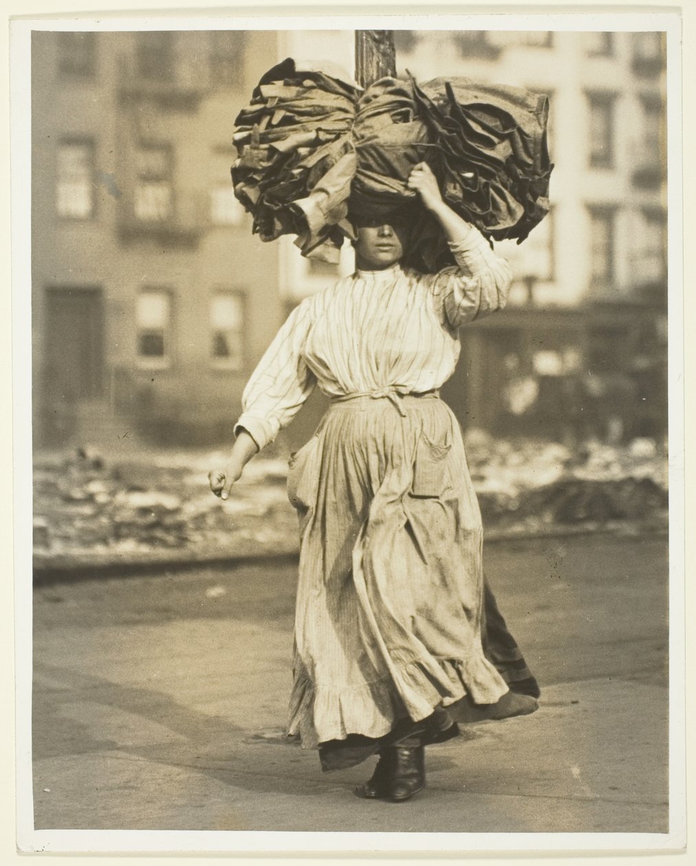 Pierwsza praca w Ameryce, włoski imigrant przenosi ubrania do kamienicy autorstwa Lewis Wickes Hine