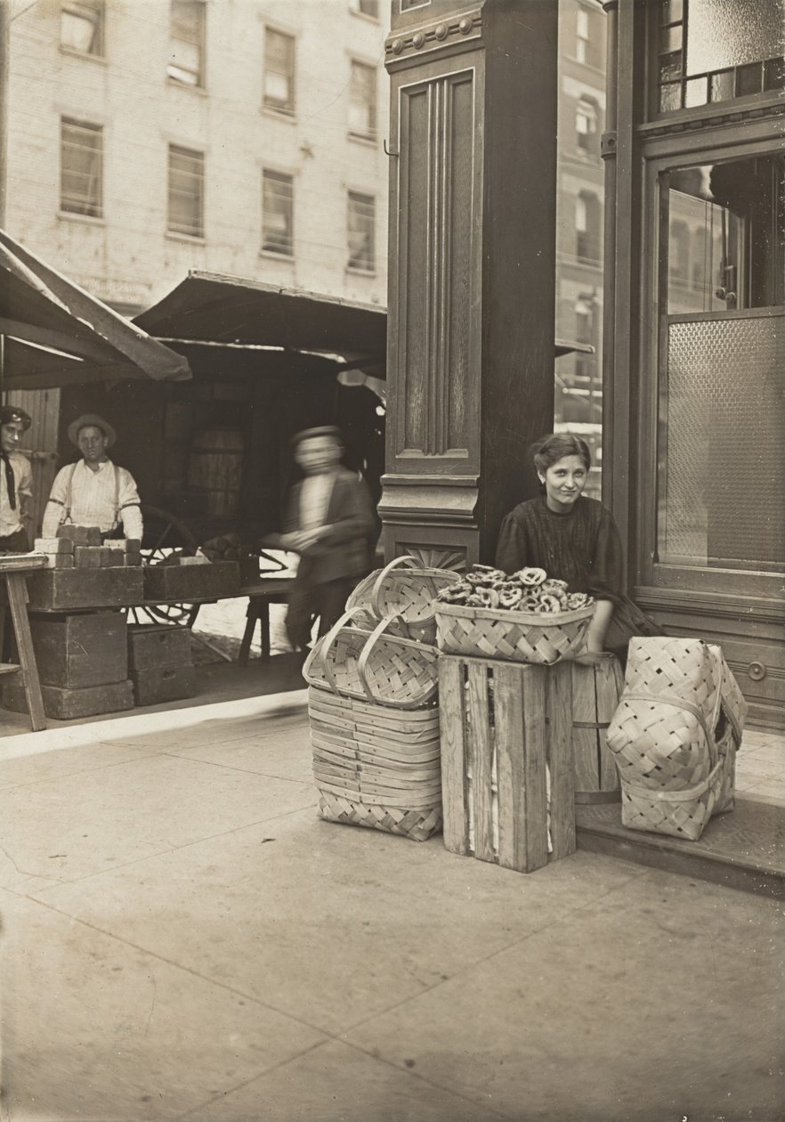 Lena Lochiavo – 11 lat, sprzedawczyni koszyków (i precli) na targu przy Sixth Street, przed wejściem do saloonu, Cincinnati, Ohio autorstwa Lewis Wickes Hine