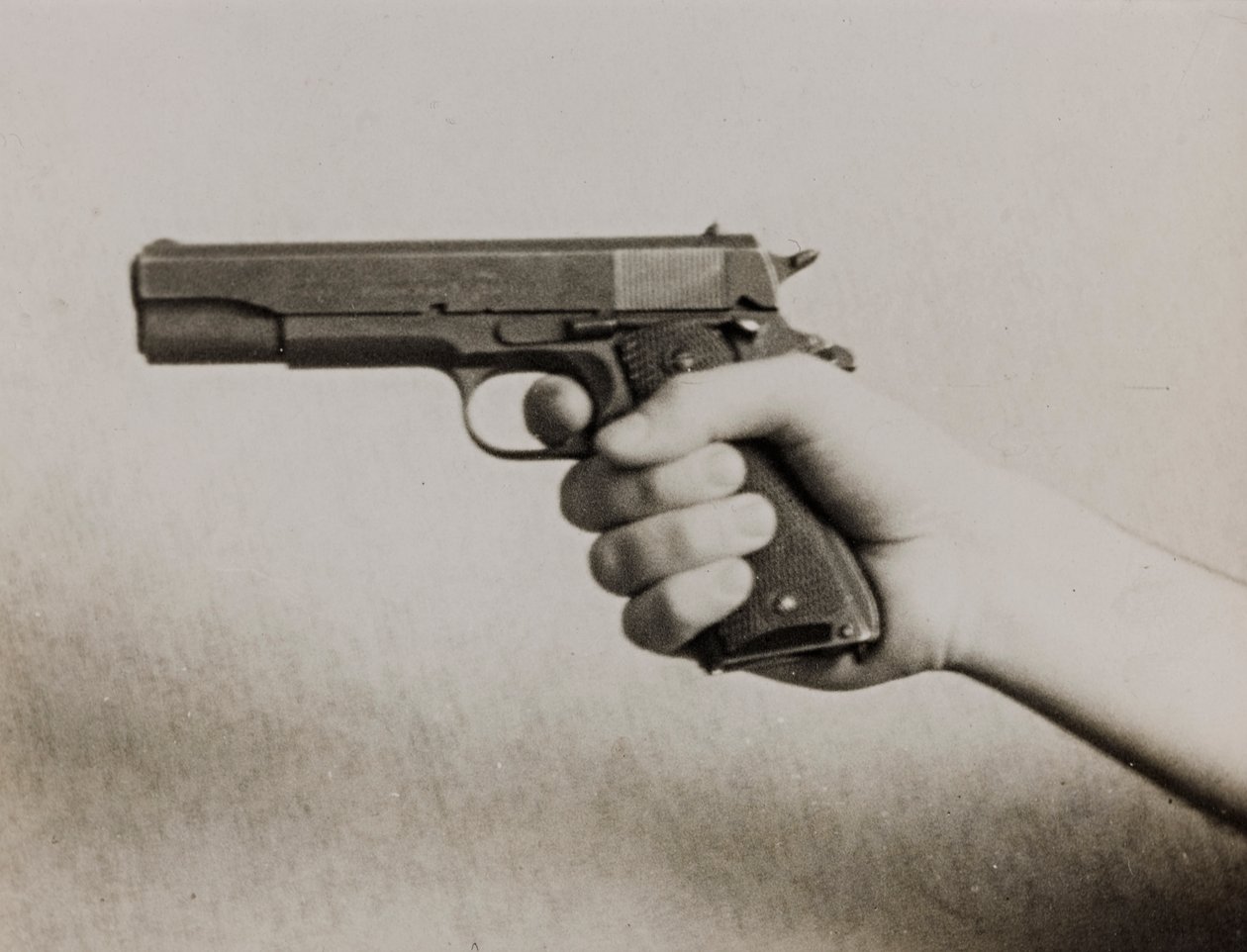 Ręka trzymająca pistolet automatyczny autorstwa Luigi Leoni