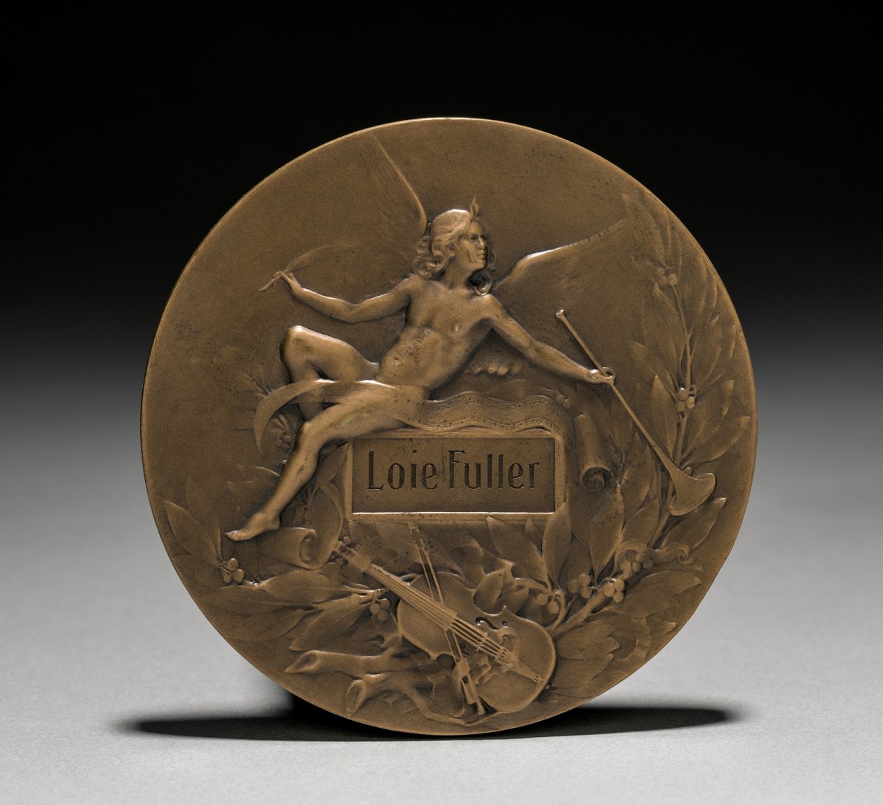 Medal wręczony Loïe Fuller przez rząd francuski: Alegoria muzyki (rewers) autorstwa Marie Alexandre Lucien Coudray