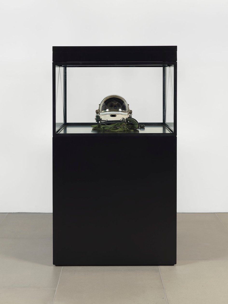 Alpha Omega, 2016 (szkło, ekran LCD, odtwarzacz multimedialny, replika czaszki, hełm kosmiczny, drewno) autorstwa Mat Collishaw