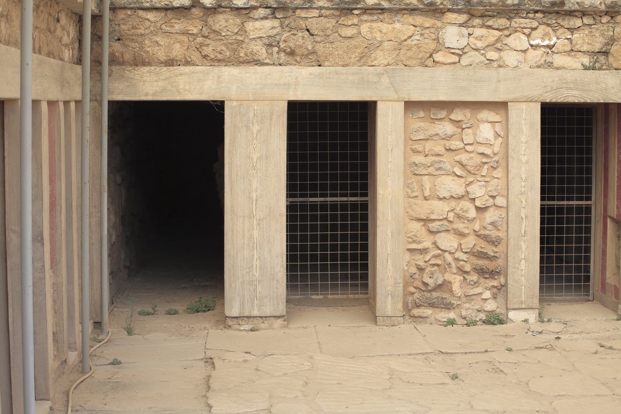 Stanowisko archeologiczne Minoen w Knossos. Skrzydło zachodnie obok „”trójstronnej kapliczki”. Pomieszczenie z dwoma dużymi prostokątnymi repozytoriami zatopionymi w podłodze. Pełno w nich glinianych wazonów i cennych beczek, wśród których znalazły się sły autorstwa Minoan