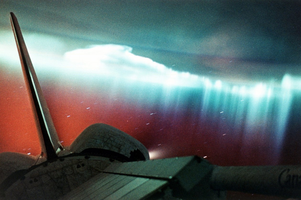 Aurora Australis (forma kurtynowa) widziana z promu kosmicznego Endeavour, którego część można zobaczyć w prawym górnym rogu pierwszego planu. Kwiecień 1994. Zdjęcie NASA. autorstwa National Aeronautics and Space Administration National Aeronautics and Space Administration