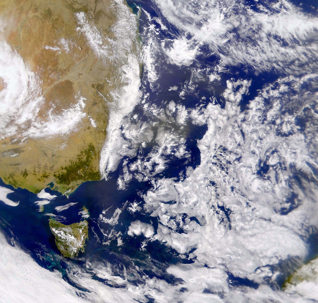 Zdjęcie satelitarne Morza Tasmana częściowo pokrytego chmurami. Po lewej część Australii, a pod nią Tasmania. NASA. Nauki ścisłe autorstwa National Aeronautics and Space Administration National Aeronautics and Space Administration
