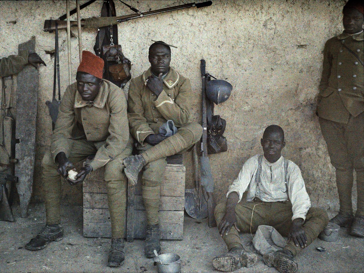 Senegalscy żołnierze służący w armii francuskiej jako żołnierze piechoty odpoczywający w pomieszczeniu z bronią i sprzętem, Saint-Ulrich, Department Haut-Rhin, Alzacja, Francja, 16 czerwca 1917 (autochrom) autorstwa Paul Castelnau