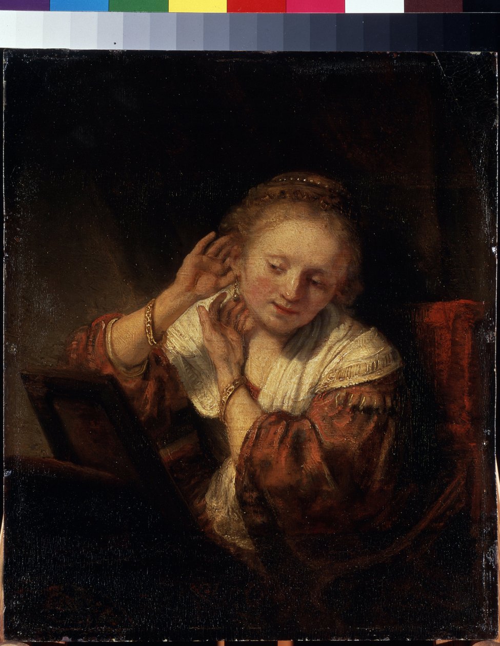 Młoda kobieta próbuje na kolczyki. Młoda kobieta próbuje na kolczyki. Obraz Harmenszoon van Rijn znany jako Rembrandt (1606-1669) autorstwa Rembrandt Harmensz. van Rijn