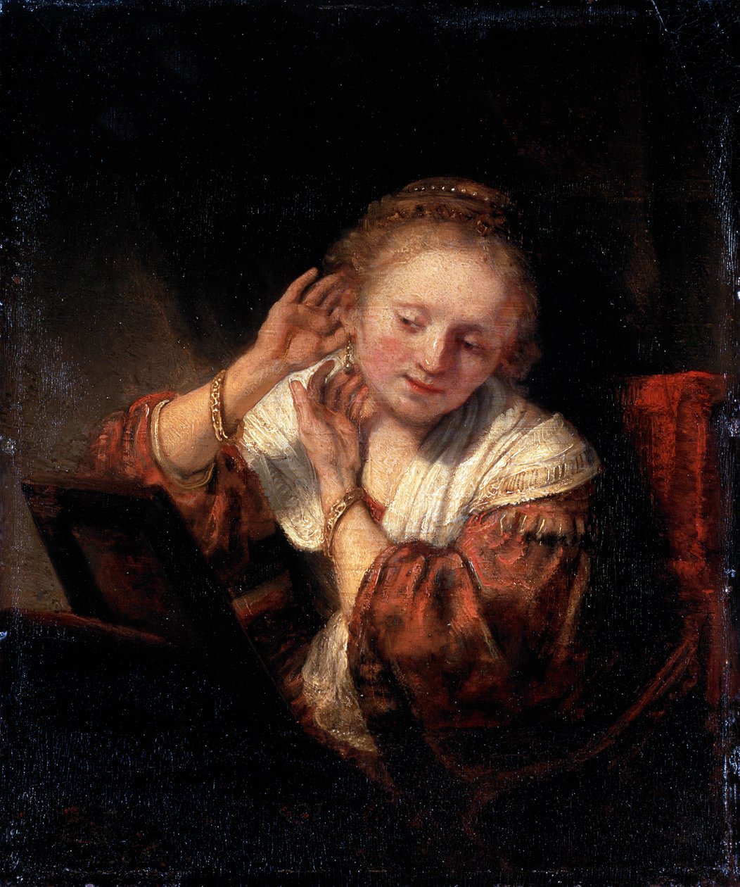 Młoda kobieta przymierzająca kolczyki, 1657. autorstwa Rembrandt van Rijn
