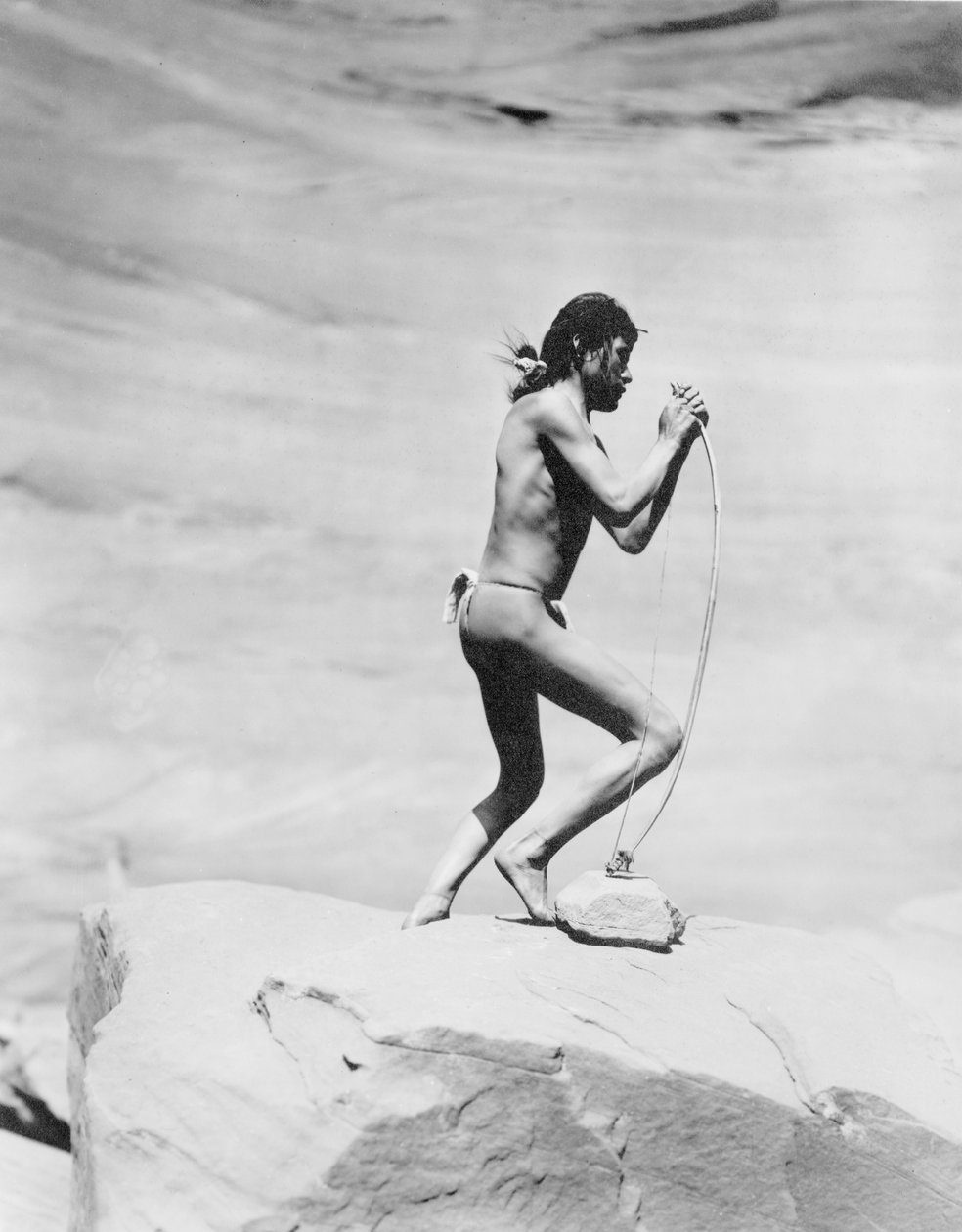 Indianin Navajo naciągający łuk, ok. 1913 (zdjęcie czarno-białe) autorstwa Roland W. Reed