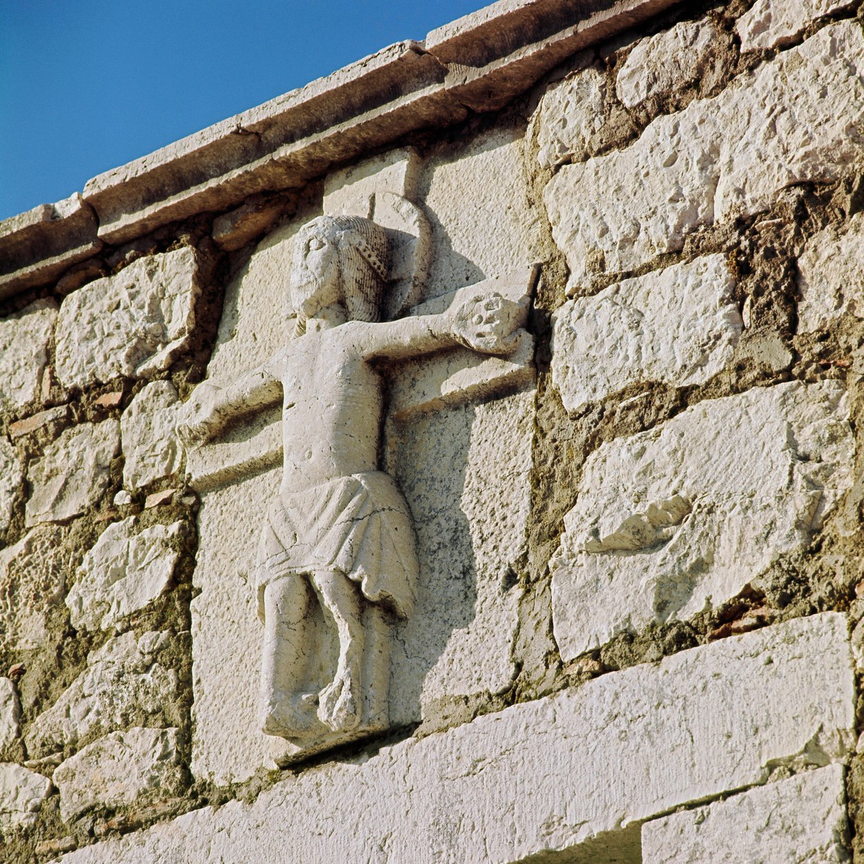 Chrystus krzyżuje Kamienna rzeźba z XIII wieku. Portal romańskiego kościoła San Bartolomeo, Campobasso Włochy autorstwa Romanesque