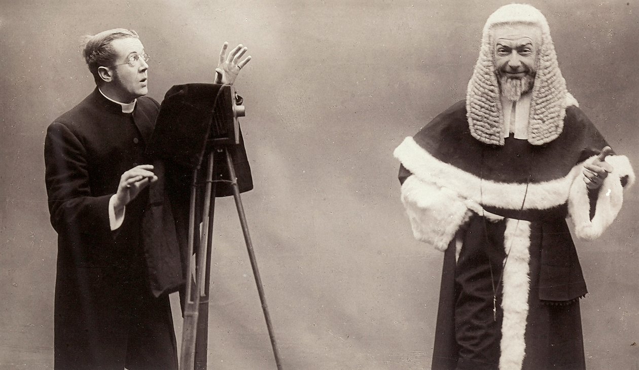 Mężczyzna w sutannie celuje obiektywem aparatu w mężczyznę przebranego za papieża autorstwa Rotary Photographic Co Ltd