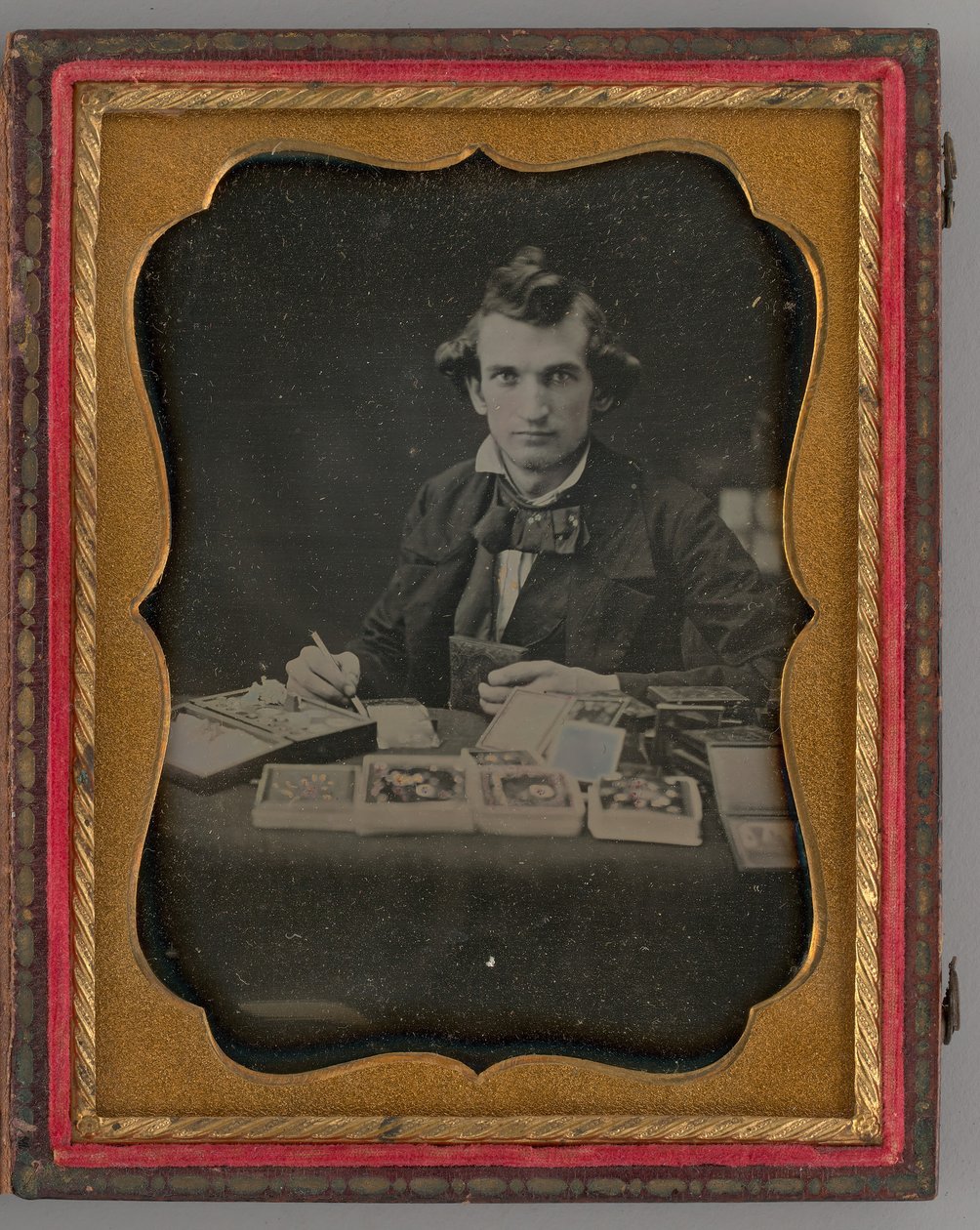 Portret bez tytułu siedzącego mężczyzny trzymającego dagerotyp i pędzel, 1865. autorstwa Samuel J. Miller