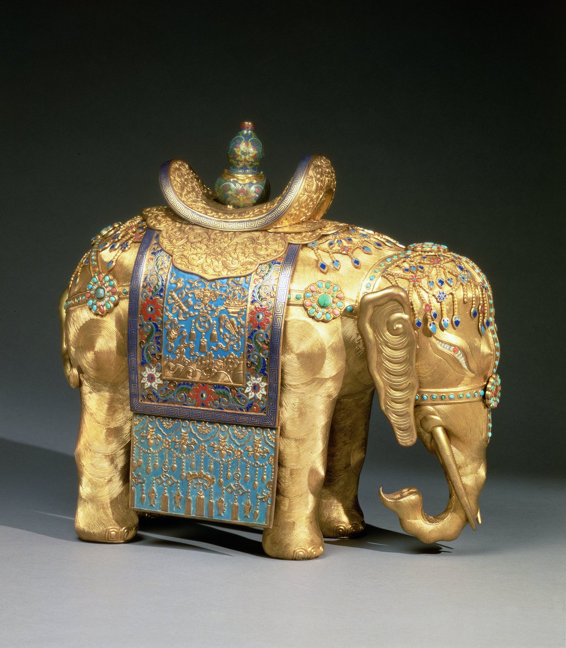 Figurka słonia, z emaliowanym uprzężą i kaboszonami z korala i turkusu, tkanina na siodło ozdobiona buddyjskimi emblematami, okres Chien Lung, ok. 1780 (złocony brąz, emalia, koral i turkus) autorstwa School Chinese