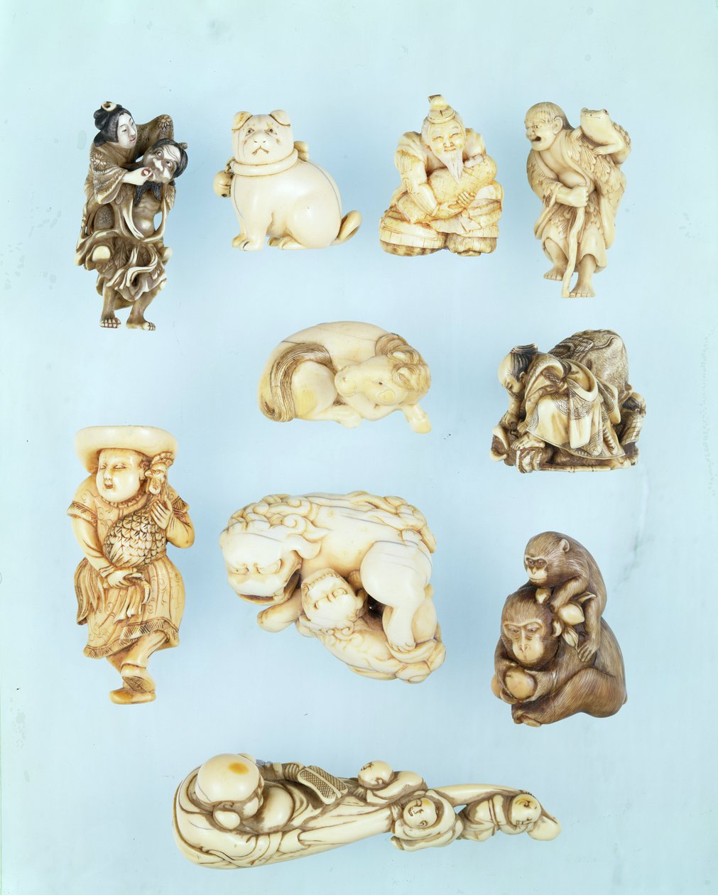 Wybór netsuke: Ikkuha Sennin niosący nierządnicę z Benares; siedzący szczeniak; Abe no Yasuneri trzymający dziecko; Gamma Sennina; leżący koń; wojownik ujarzmiający uciekającego wołu; stojący Holender trzymający koguta długoogoniastego; siedząca małpa trzy autorstwa Japanese School