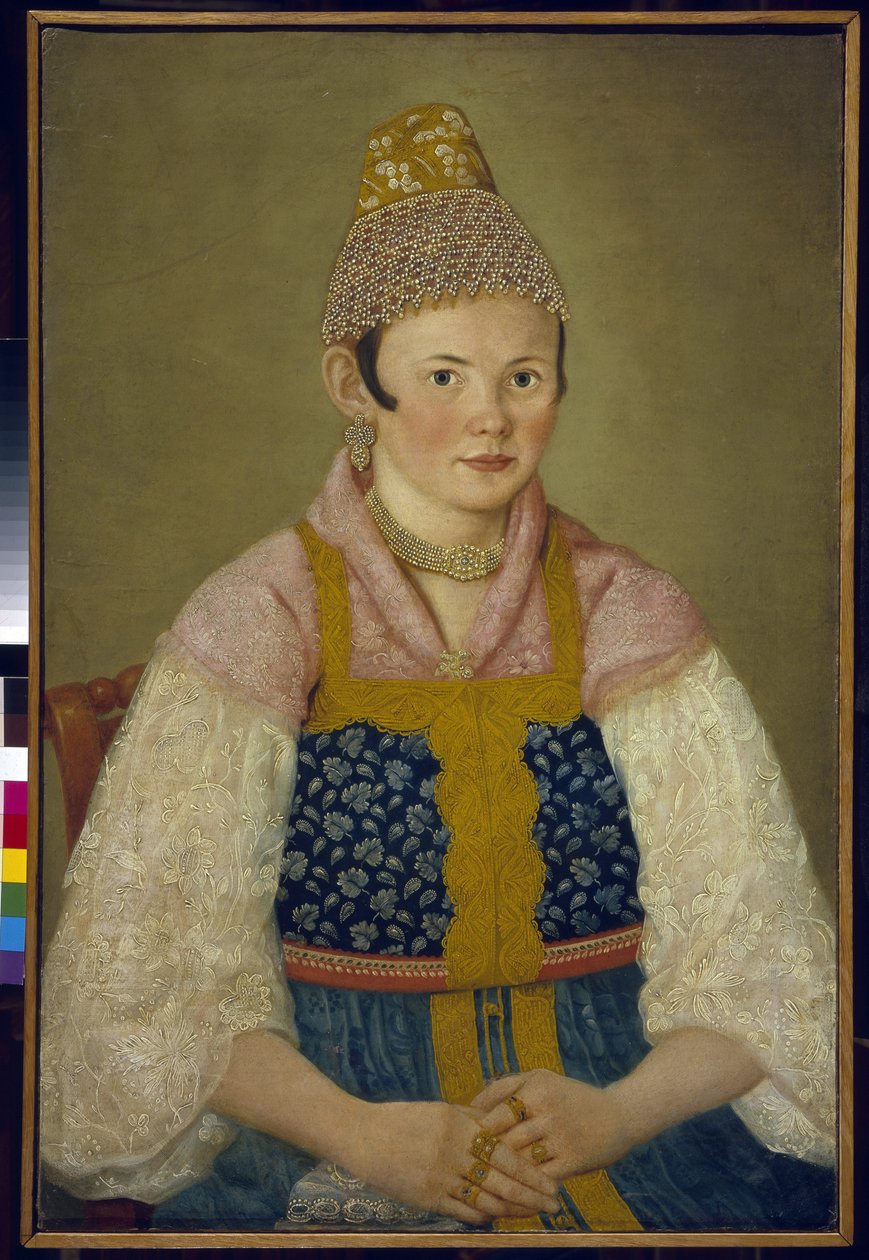 Portret żony kupca, nakrycie głowy tradycyjnego kokosznika. (Portret kupcy w Kokoszniku Kabluchok). Nosi również tradycyjną rosyjską sukienkę (sarafane) ozdobioną haftem, bluzkę z koronkowymi rękawami, nakrycie głowy autorstwa School Russian