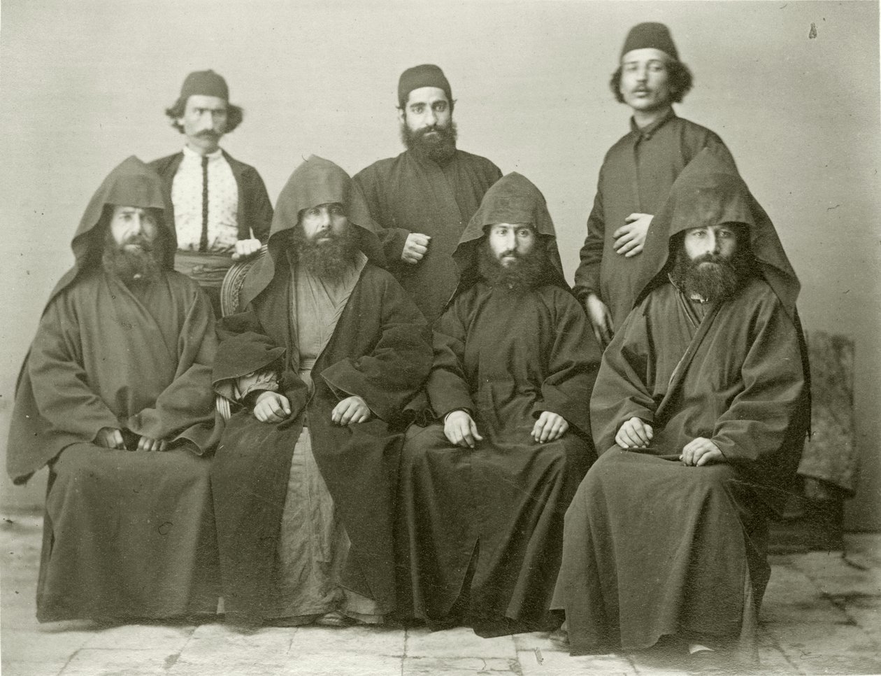 Grupa 4 ormiańskich księży i 3 innych osób na dziedzińcu Hotelu Śródziemnomorskiego, Jerozolima, 1867 r. autorstwa Sergeant Henry Phillips