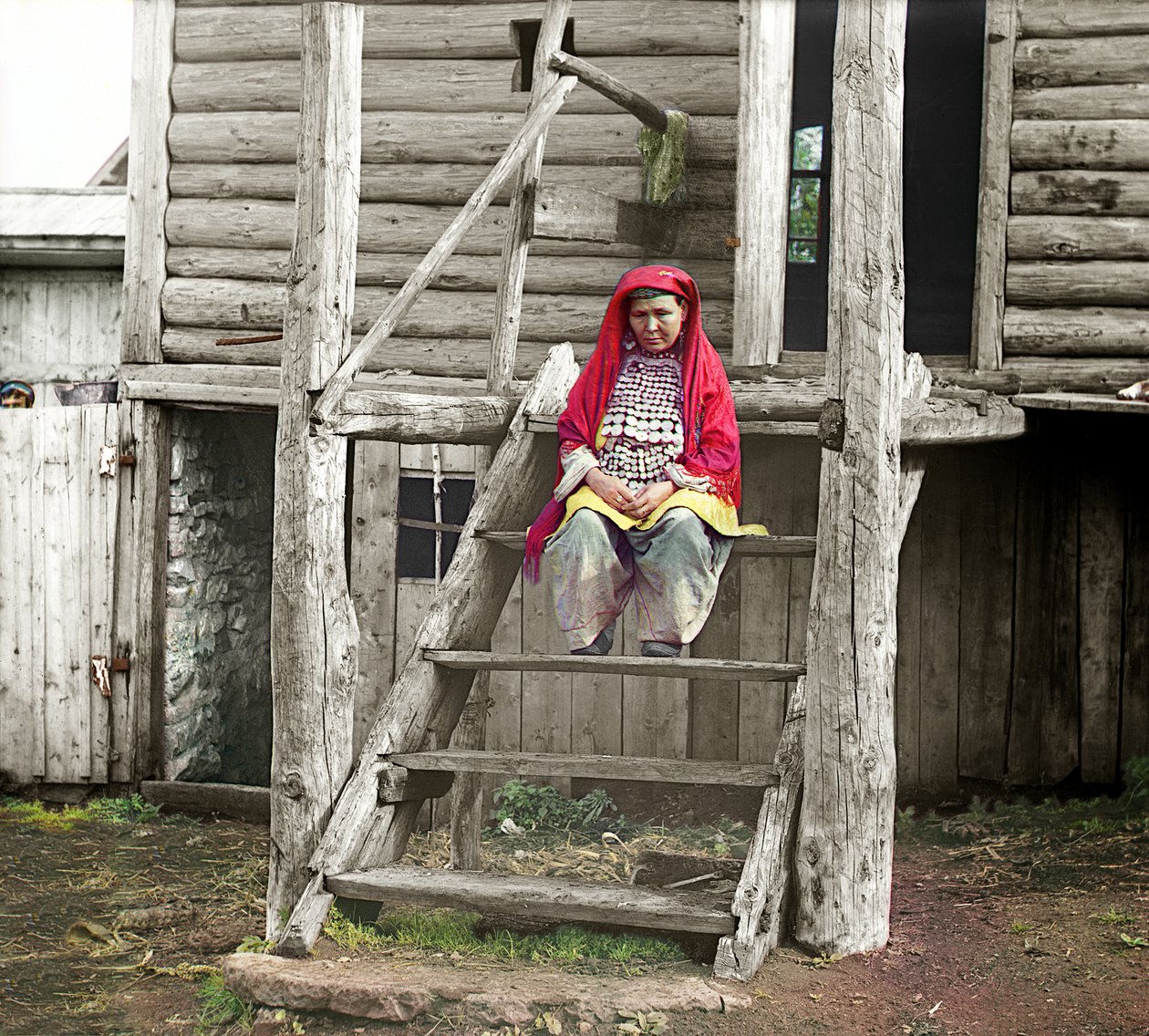 Baszkirska kobieta w stroju ludowym siedząca na schodach swojego drewnianego domu, Ural, Imperium Rosyjskie, 1910 autorstwa Sergey Prokudin Gorsky