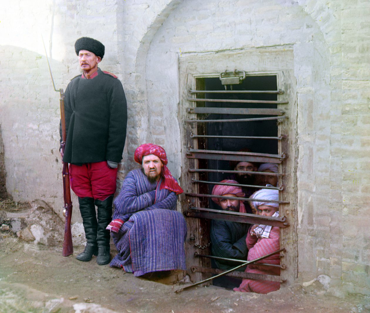 Więzienie Zindan, z więźniami i strażnikiem z rosyjskim karabinem, mundurem i butami, Azja Środkowa, Imperium Rosyjskie, między 1905 a 1915 autorstwa Sergey Prokudin Gorsky