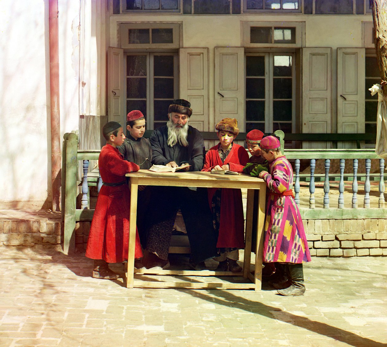 Grupa dzieci żydowskich z nauczycielem na stole przed domem, Samarkanda, Imperium Rosyjskie, w latach 1905-1915 autorstwa Sergey Prokudin Gorsky