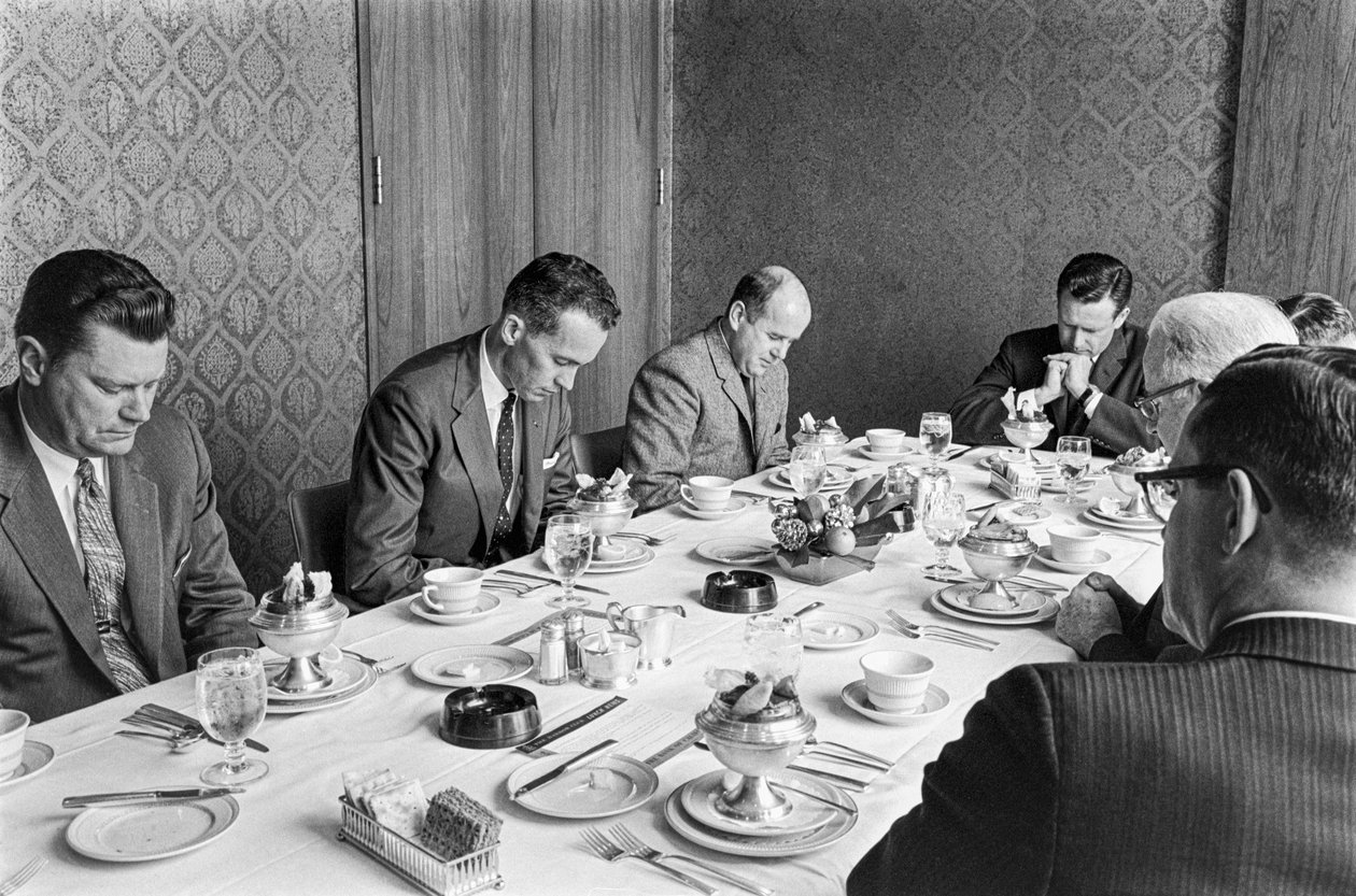 Biznesmeni modlący się przed rozpoczęciem lunchu na spotkaniu dotyczącym zbierania funduszy w kościele autorstwa Ted Spiegel