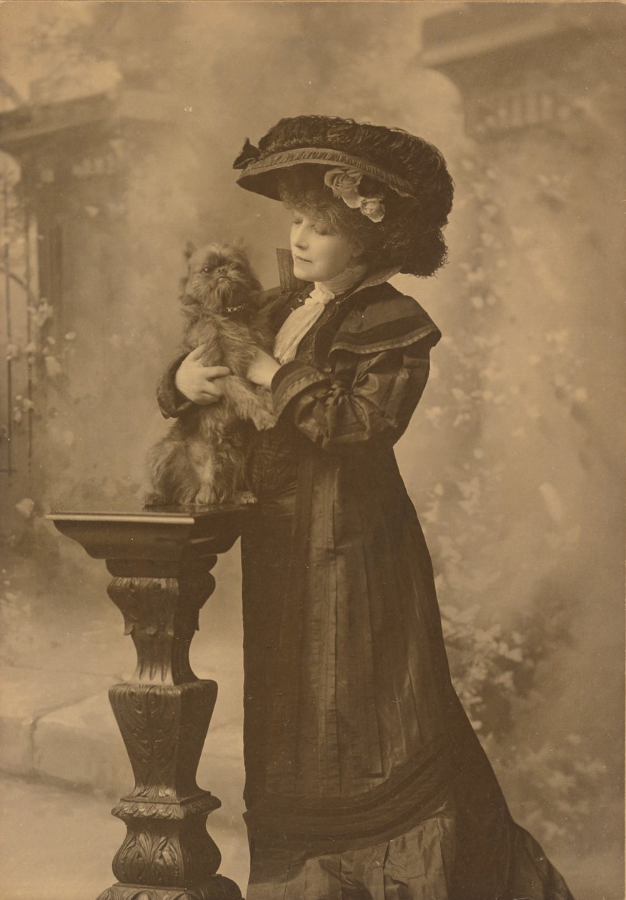 [Sarah Bernhardt stojąca w studiu, trzymająca małego czarnego pieska na ozdobnym, rzeźbionym drewnianym postumencie]. autorstwa Theodore C. Marceau