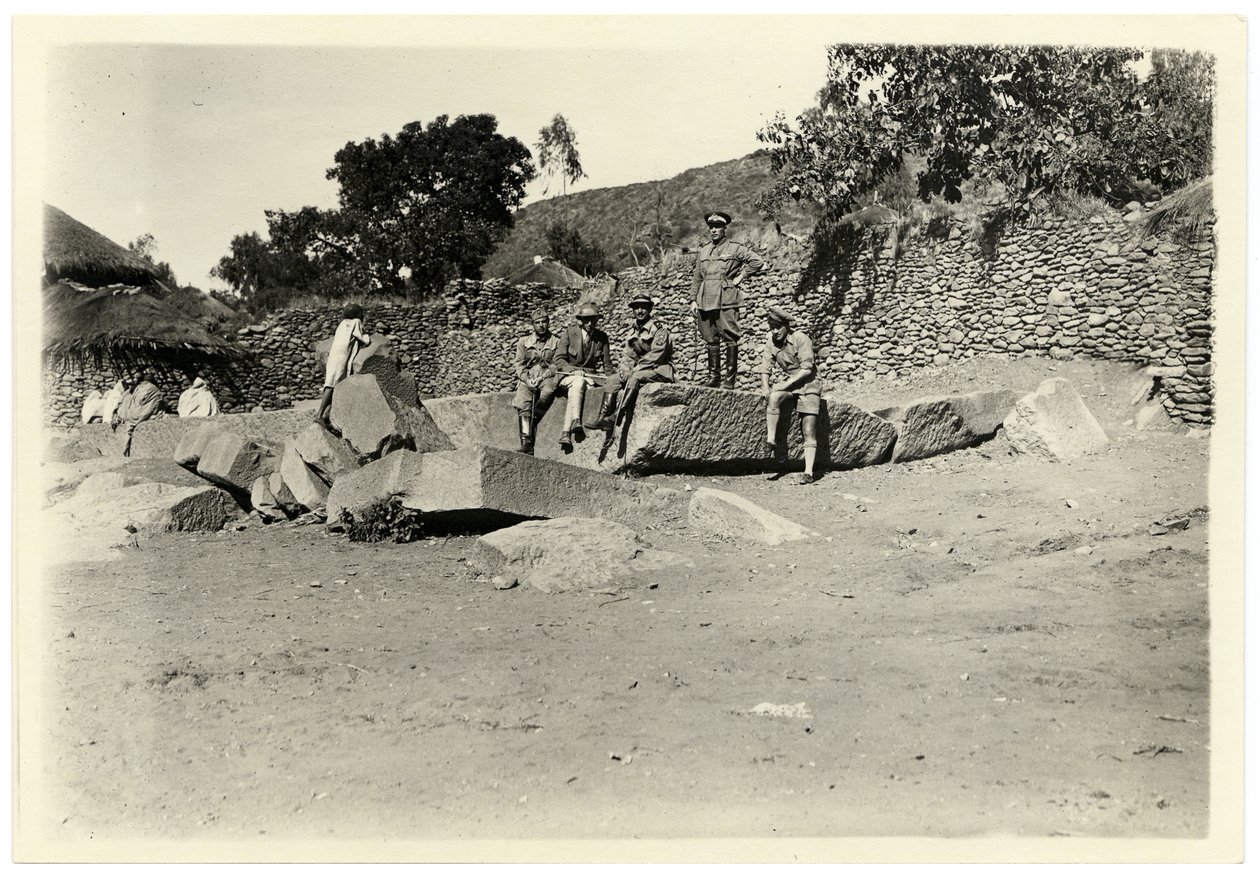 Archeolog Ugo Monneret de Villard z włoskimi żołnierzami siedzącymi na rozbitej steli, Aksum, Etiopia, fot. Ugo Monneret de Villard autorstwa Ugo Monneret de Villard