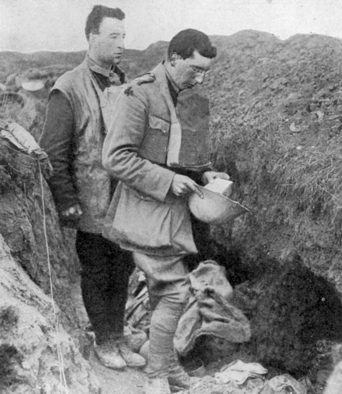 Kapelan Ist Munsters odmawia modlitwę pogrzebową nad żołnierzami zabitymi w ich okopach, 1918 autorstwa Unbekannt