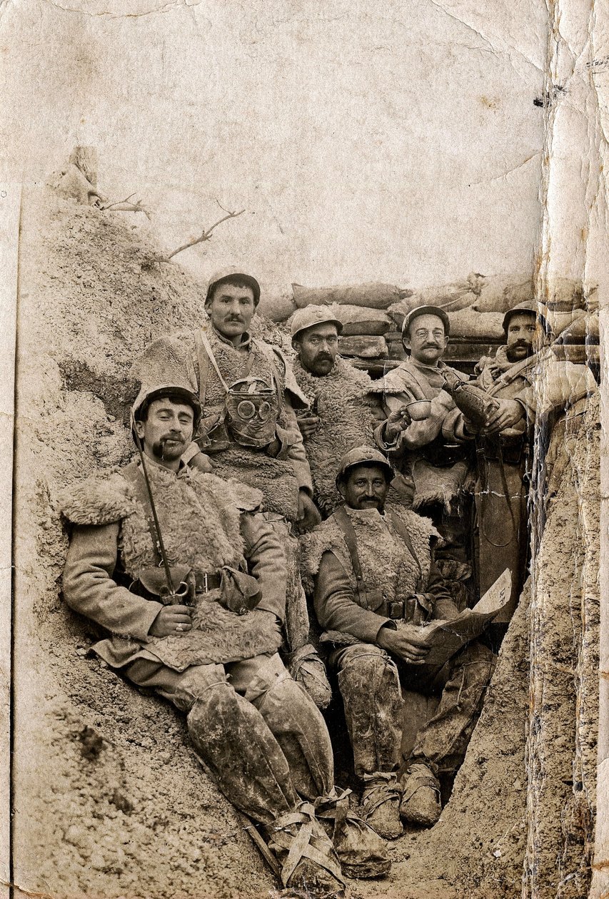 I wojna światowa (1914-1918): Włochaci żołnierze w zimowym stroju w okopie w latach 1916-1917. Noszą kurtki z owczej skóry i maskę przeciwgazową. autorstwa Unbekannt