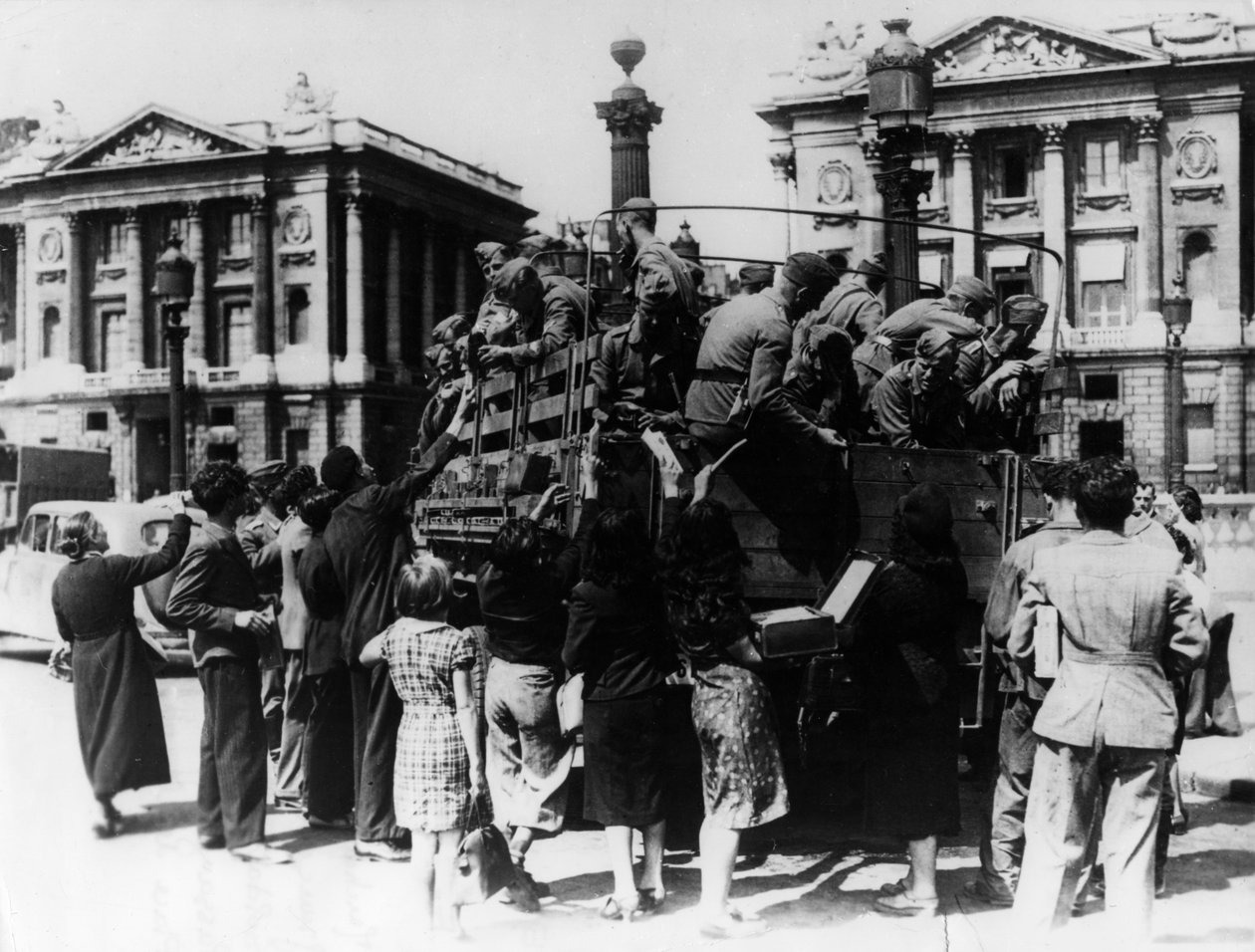 Francuscy sprzedawcy uliczni oferujący upominki ciężarówce żołnierzy niemieckich, Paryż, 27 lipca 1940 r autorstwa Unbekannt